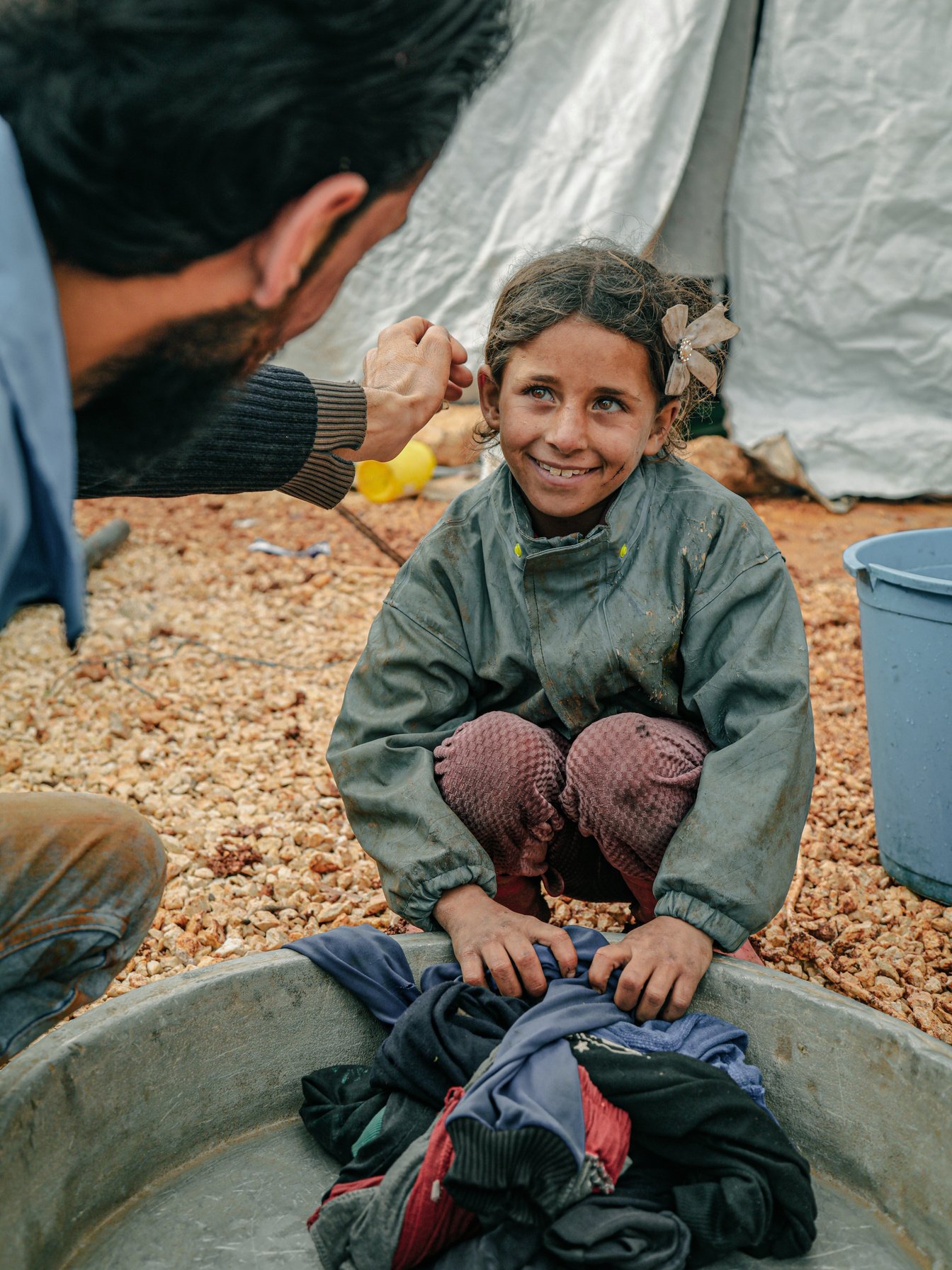 a person is touching the face of a young smiling child