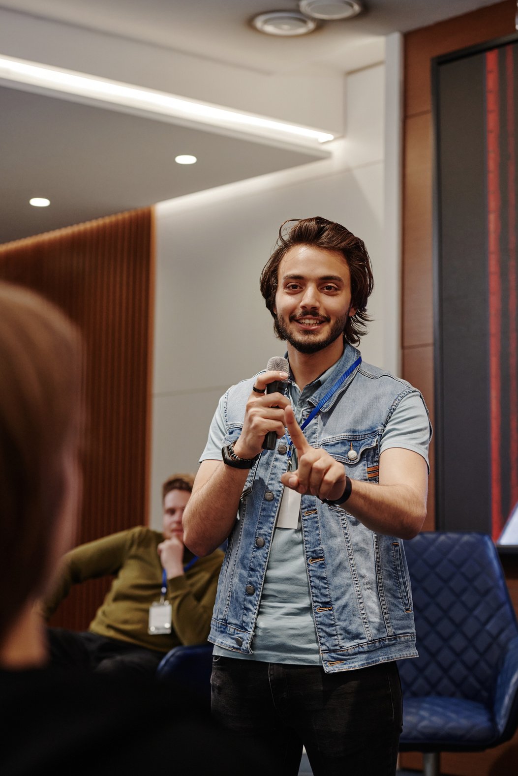 a person in a denim shirt holding a microphone